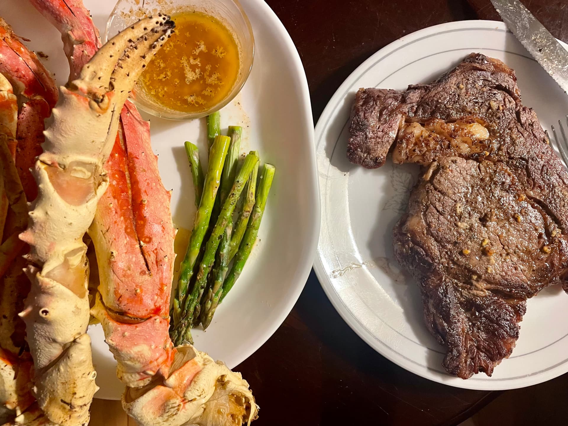 Surf and turf — king crab legs with drawn butter, asparagus, and a grilled ribeye