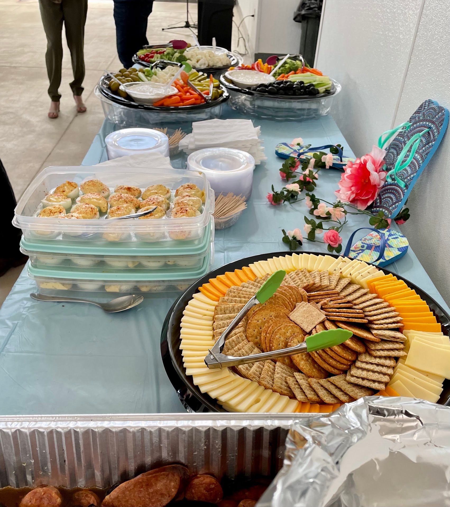 Appetizer table with deviled eggs, veggie trays, and a cheese and cracker platter