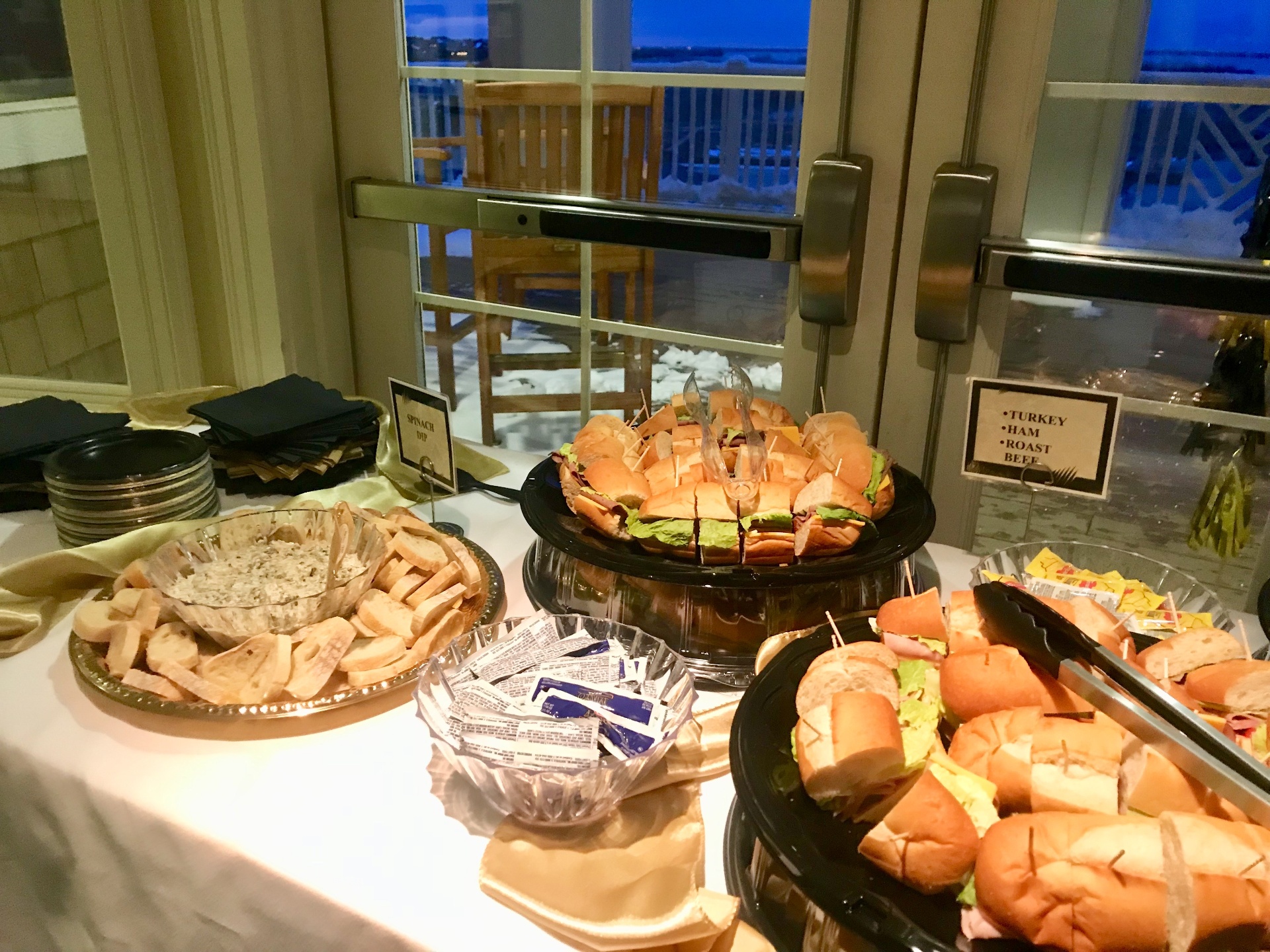 Elegant catered spread with turkey, ham, and roast beef sliders and spinach dip