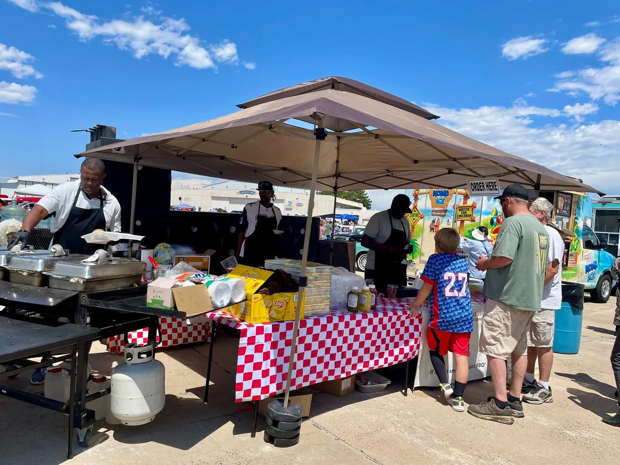 Taste of Texas BBQ vending tent with the crew serving a line of customers
