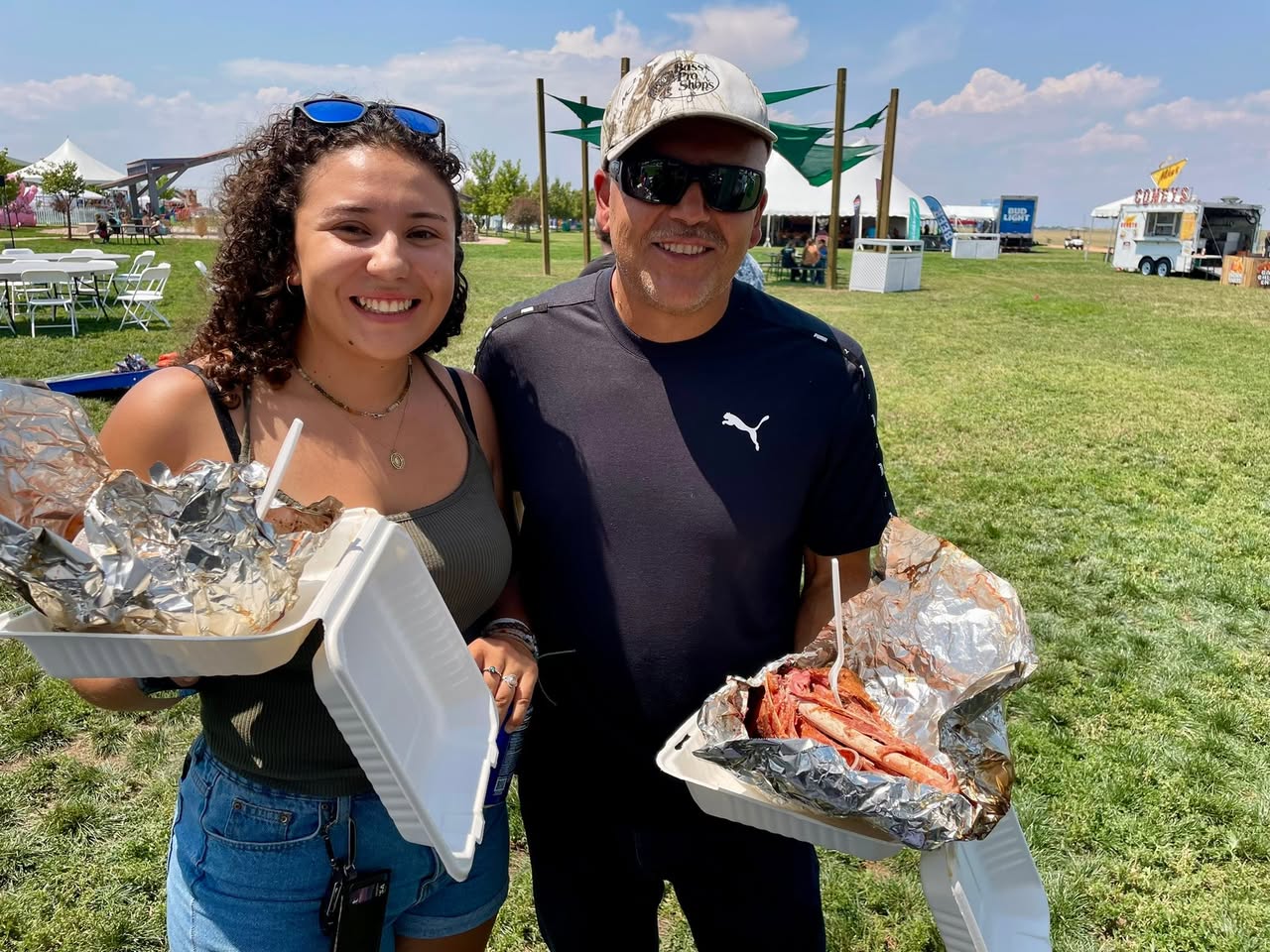 Two happy festival customers holding smoked turkey legs