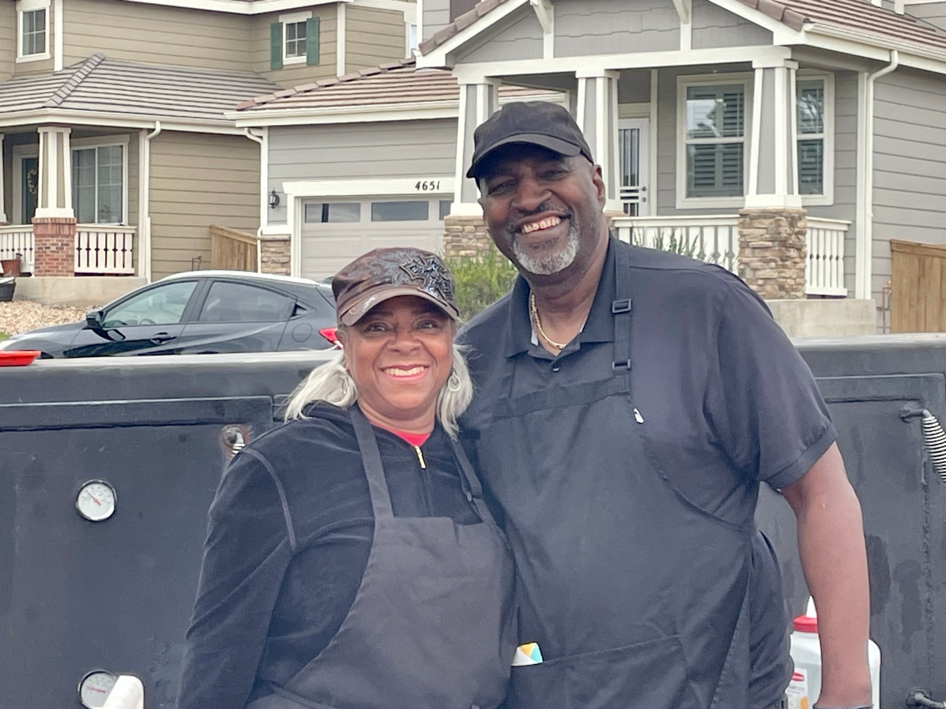 Bruce & May Washington, pit master and owners, in front of their custom smoker