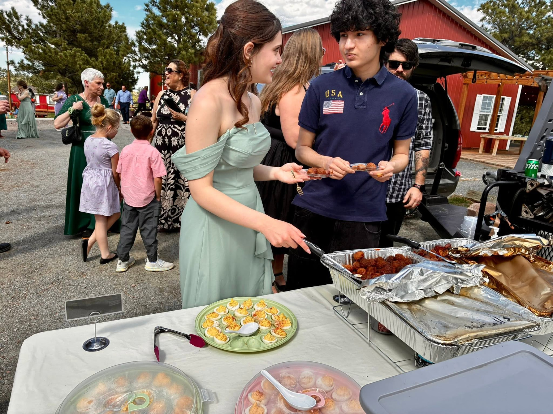 Wedding guests serving themselves BBQ meatballs and deviled eggs from the appetizer table