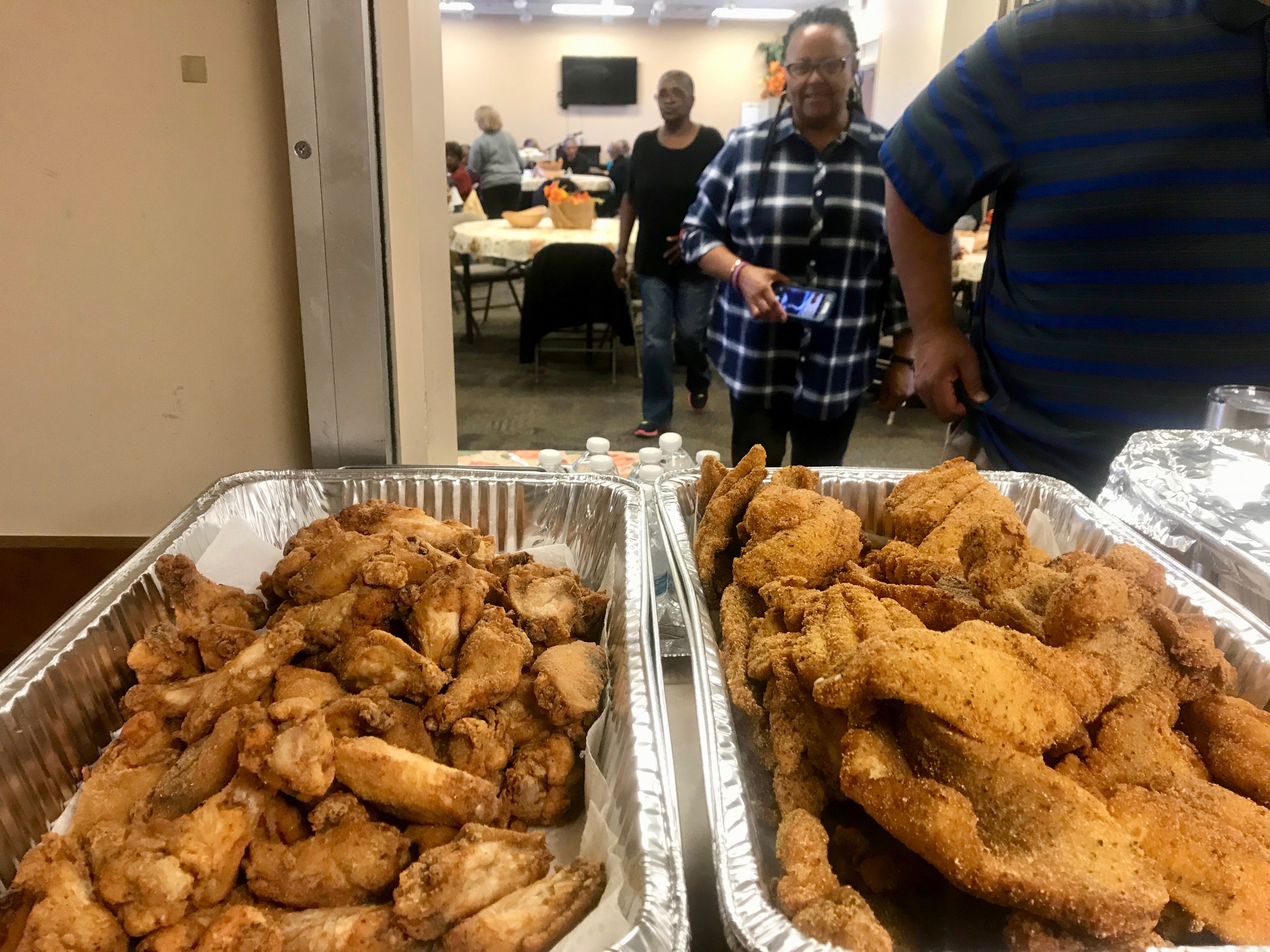 Trays of fried chicken wings and cornmeal-crusted catfish at a community event